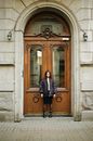 Teenage Girl Standing in Door of Classic 19th Century Building