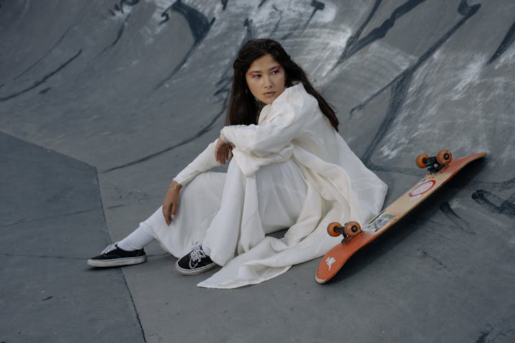 A Woman Sitting On A Skate Ramp