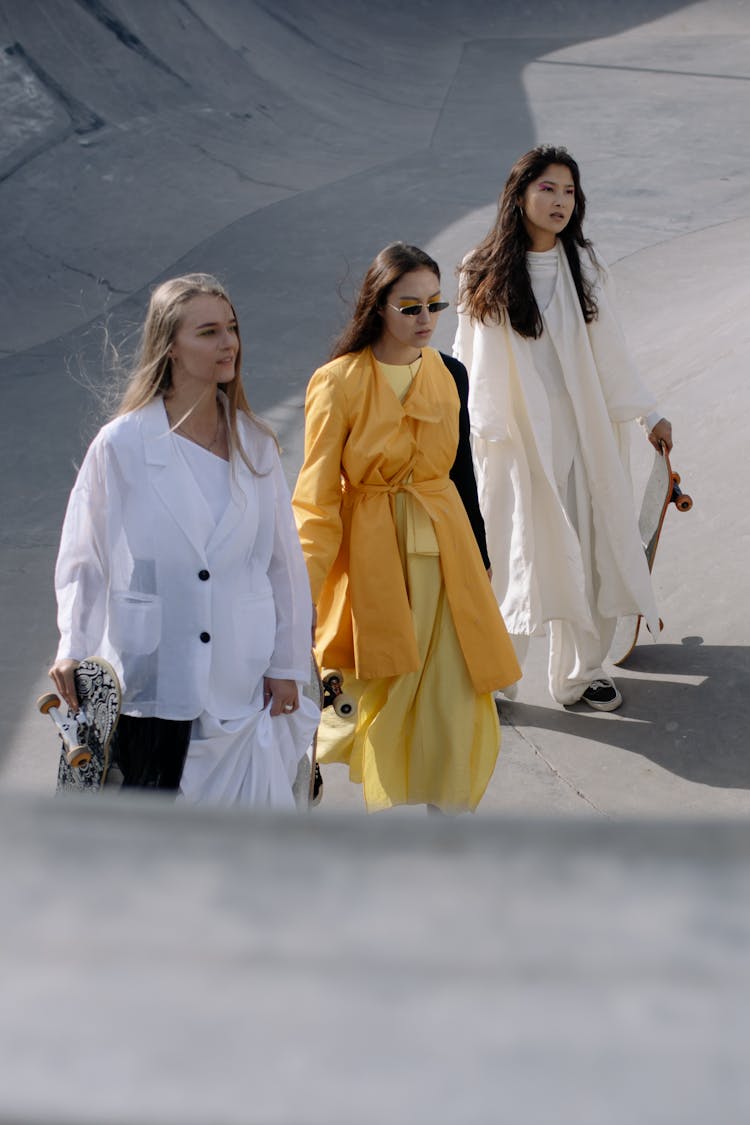 Women In Long Dresses Holding Skateboard Walking On Skate Park