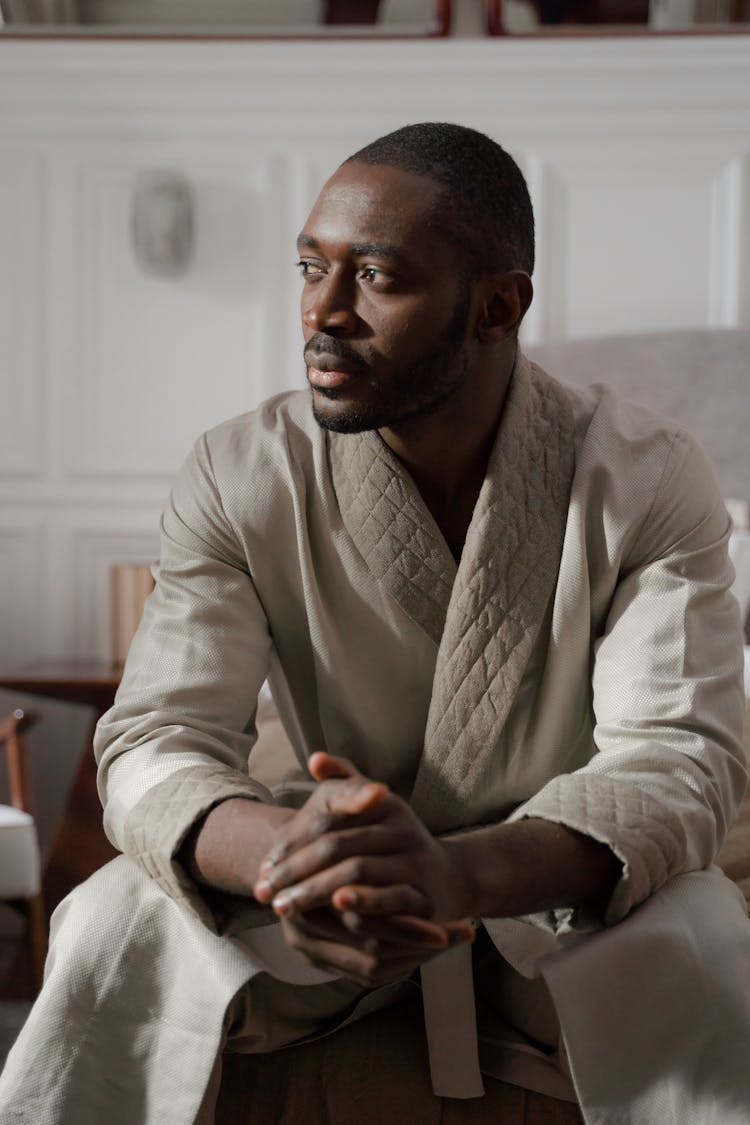 A Man Sitting While Wearing A Bathrobe