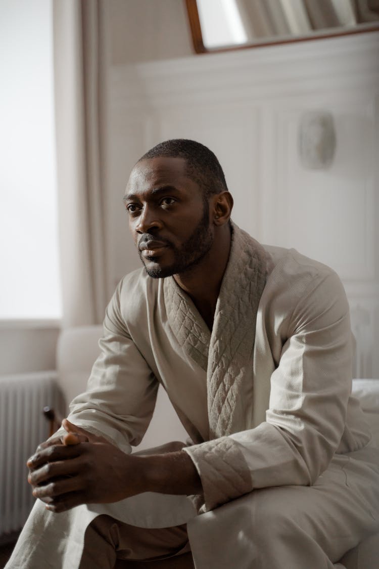 Man Sitting In A Bathrobe At Home