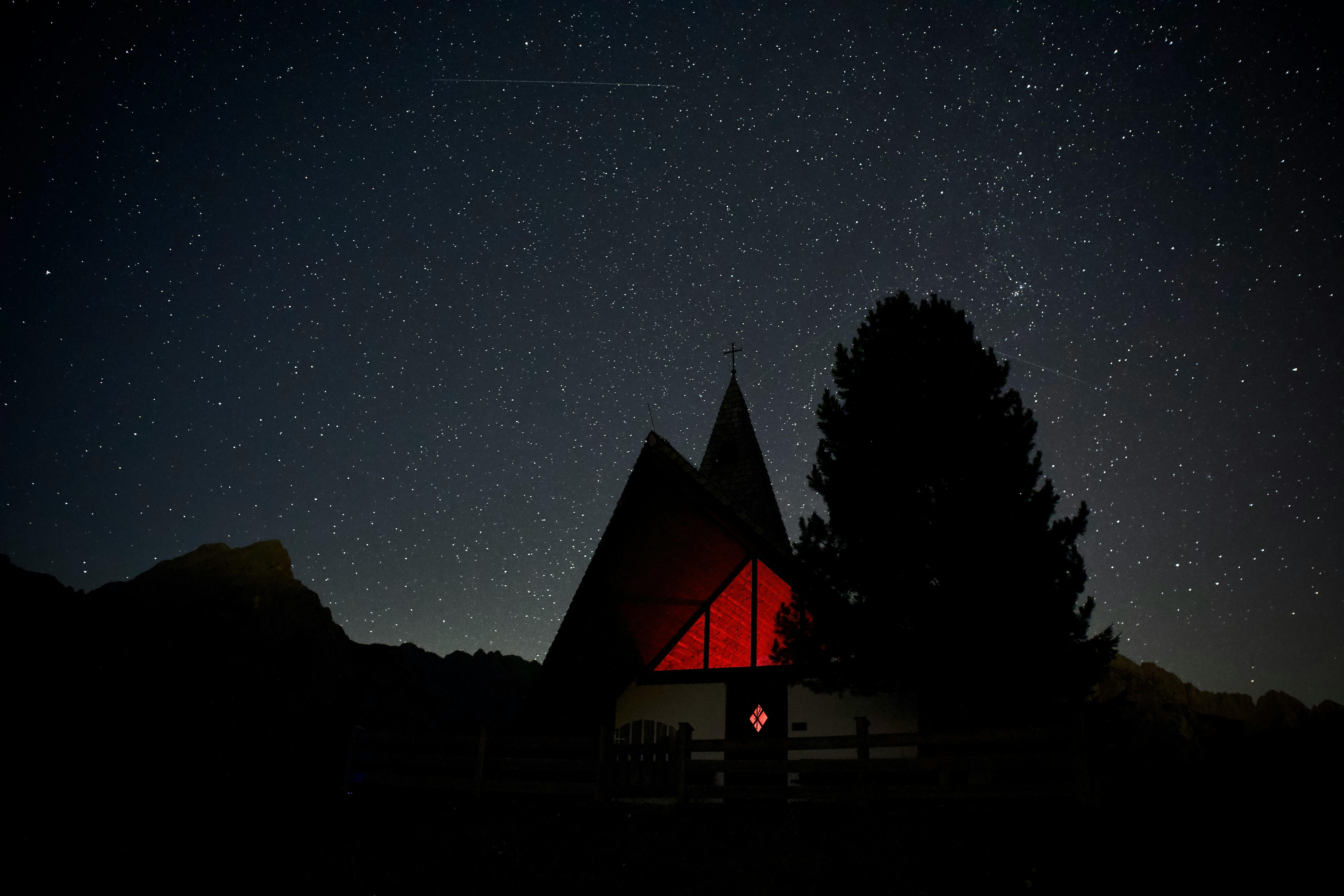 A tranquil night view of a chapel under a starry sky in Gnadenwald, Tirol.