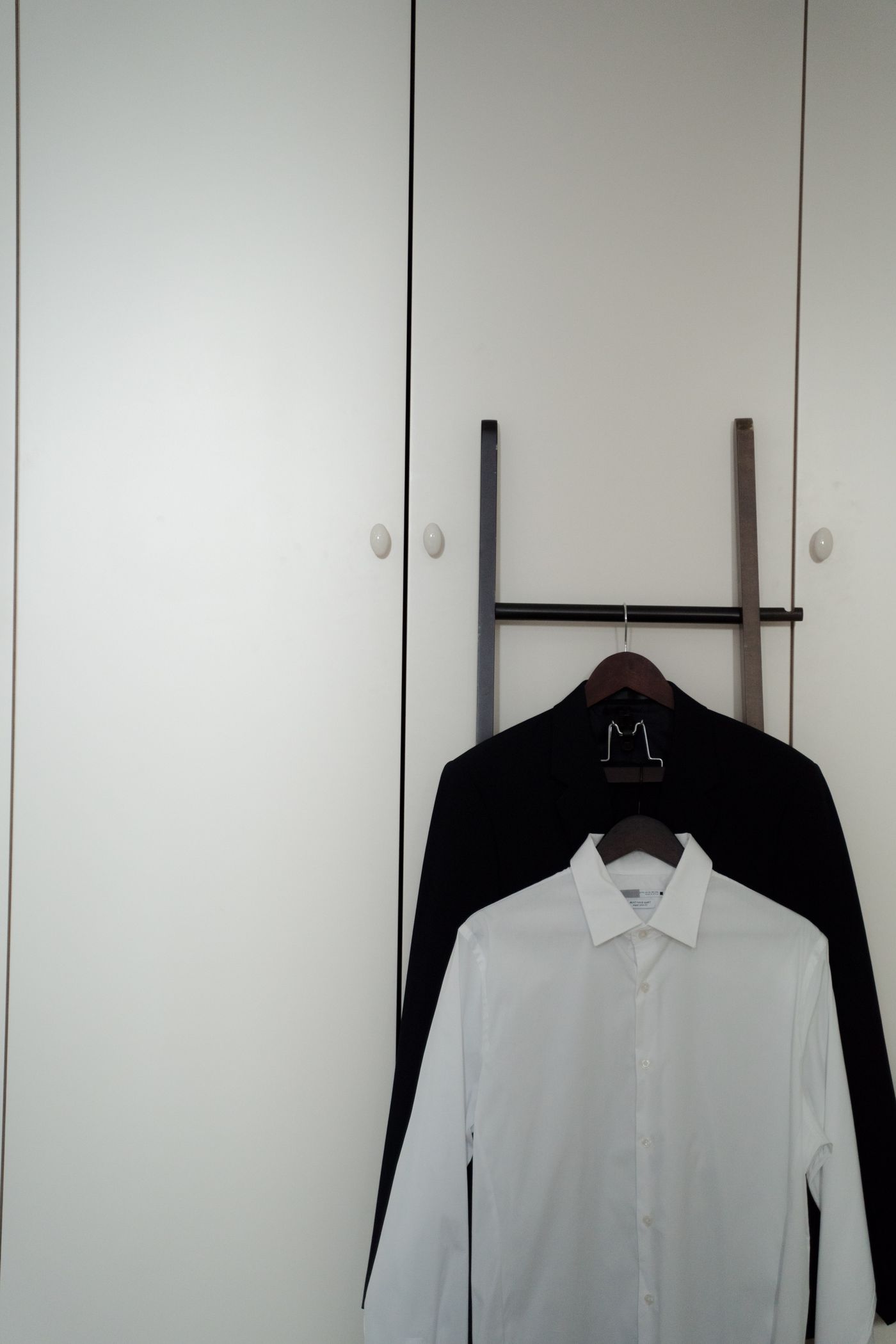 Neatly arranged shirts in a minimalist wardrobe without people