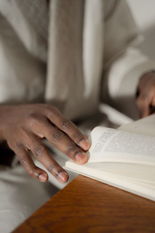 Free A close-up of a man's hands flipping through a book indoors. Stock Photo