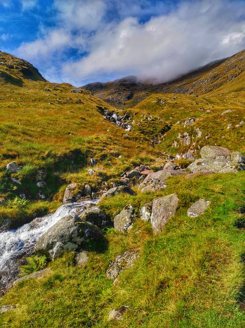 Free Breathtaking view of a mountain trail in the UK highlands with rocks and cloudy sky. Stock Photo