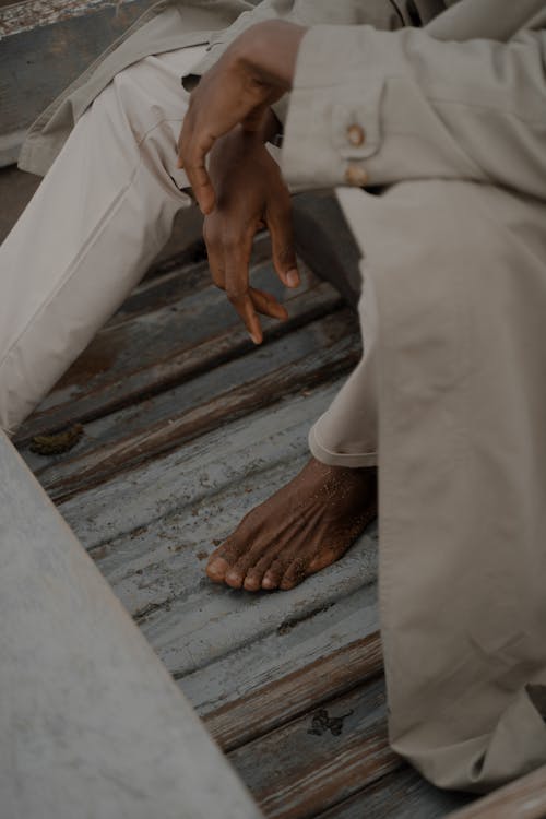 Free Barefoot Man in Coat Sitting in Boat Stock Photo
