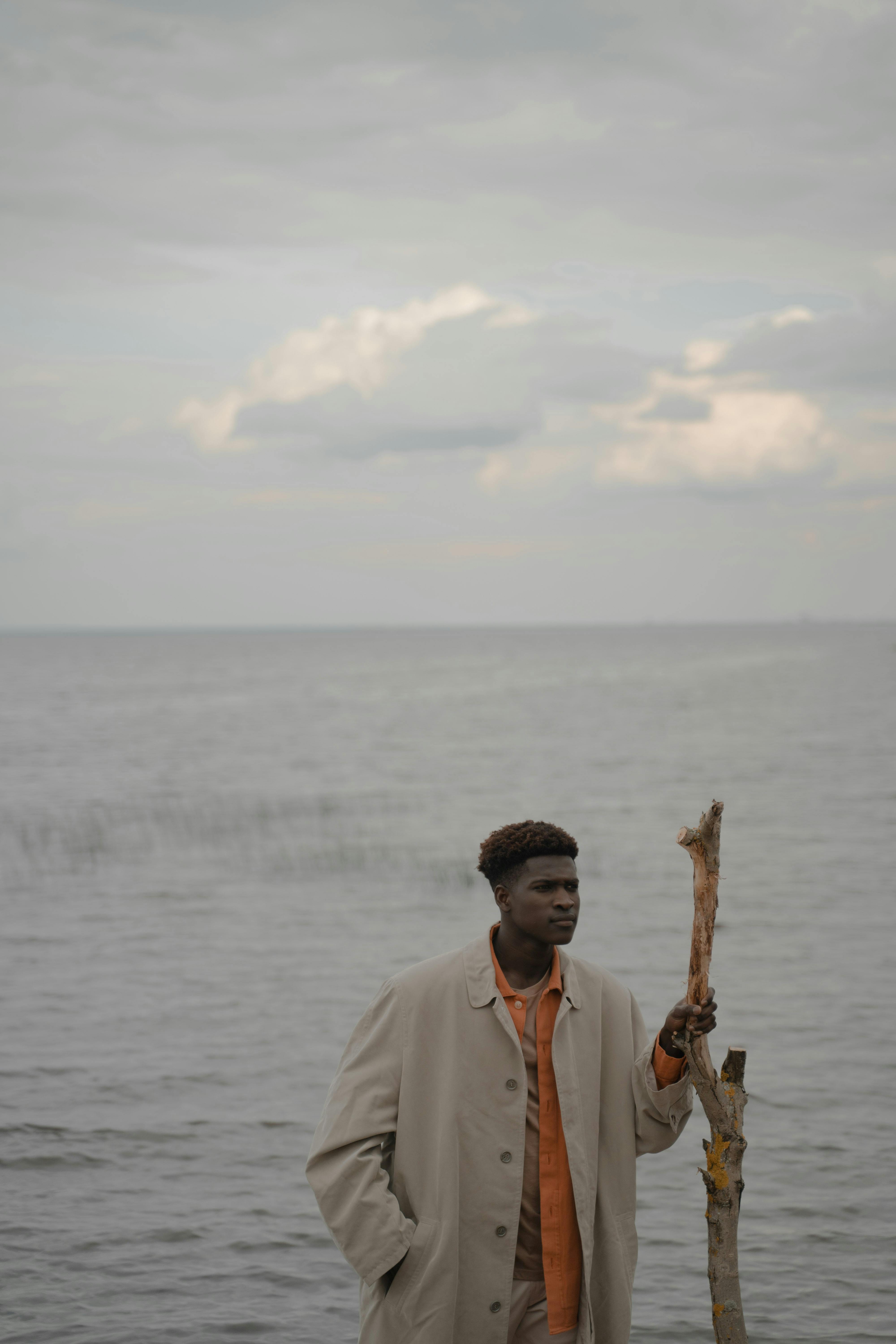 Man in Coat Standing and Holding Branch · Free Stock Photo