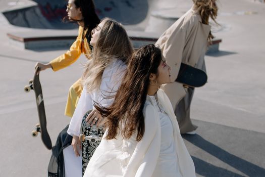 Diverse group of stylish women skating at an outdoor skate park. Capturing motion and style.