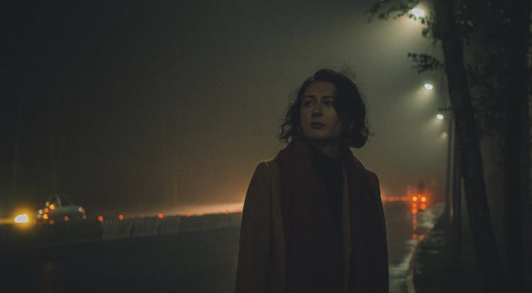 Woman Standing On Side Of Highway In Rain