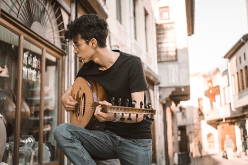 Fotobanka s bezplatnými fotkami na tému čierne vlasy, gitara, hranie