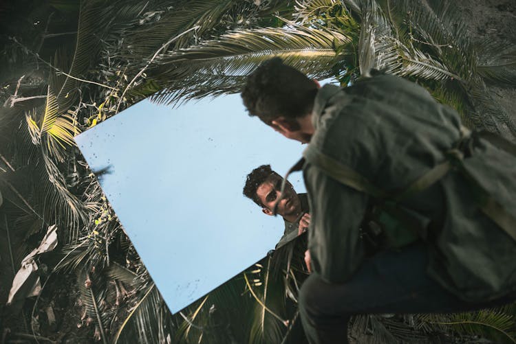 Man Face Reflection In Mirror And Plants