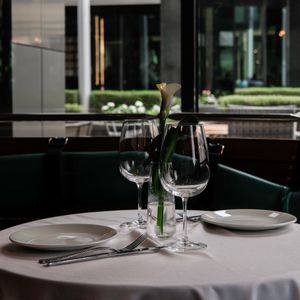 Laid dining table with glasses and a single stem — photo by Anna Belousova on Pexels