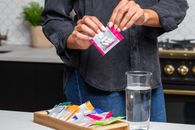 Person in Blue Denim Jacket Holding White and Red Card