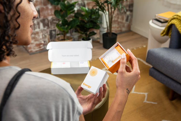 Photo Of A Woman Holding A Package With Supplements