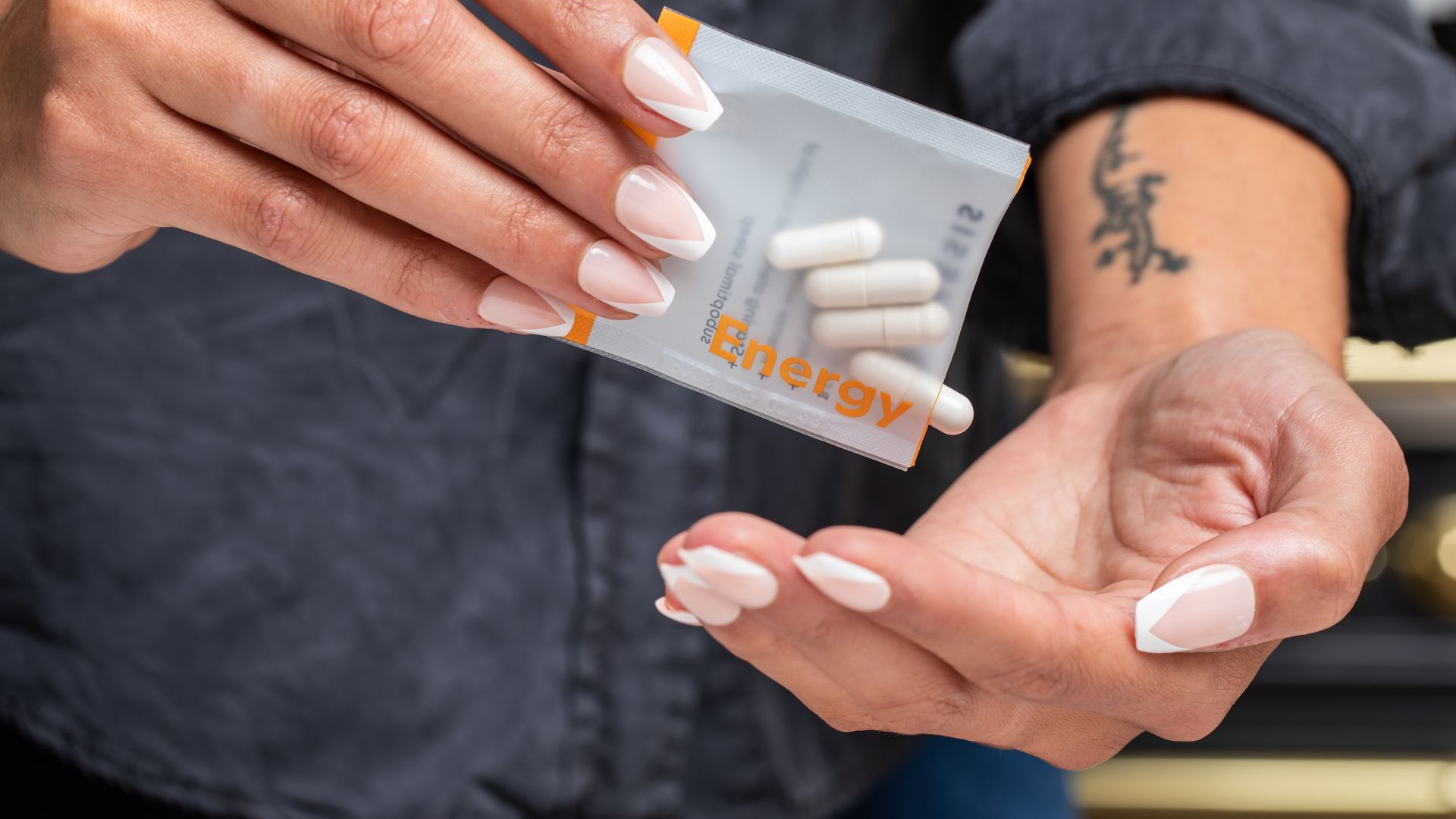 Unleash Energy with Modafinil: Your Ultimate Guide Close-up of woman's hands holding a packet of energy supplement capsules.