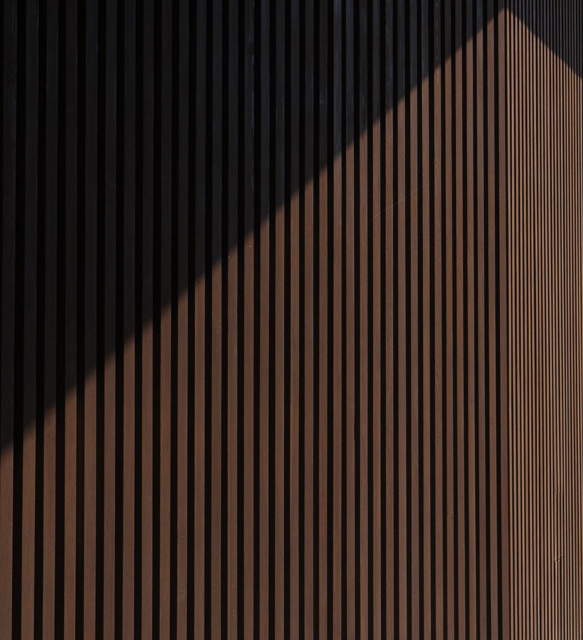 Matt black slat wall behind a media console in a modern living room