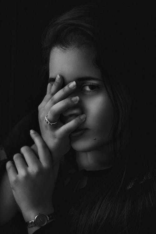 Free A Black and White Photo of a Woman Covering her Face with Hand Stock Photo