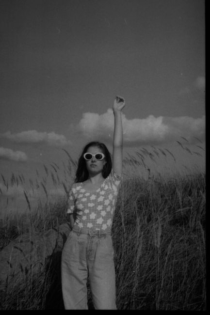 Black and white photo of a woman with raised arm in a field in Chelyabinsk.