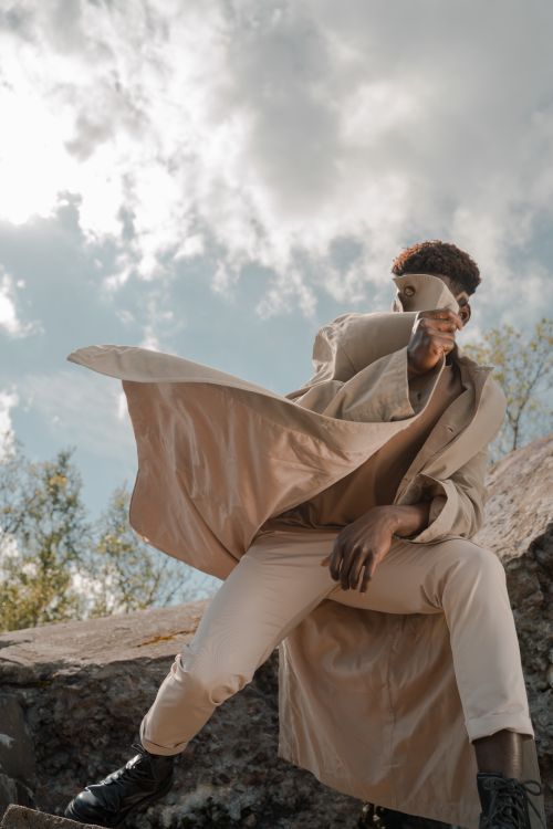 A Low Angle View of a Male Covering His Face With a Coat · Free Stock Photo