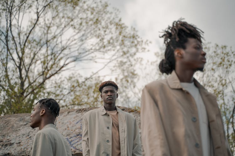 Men Standing In Forest Looking Around