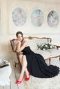 Lady Sitting on a Sofa in a Black Dress