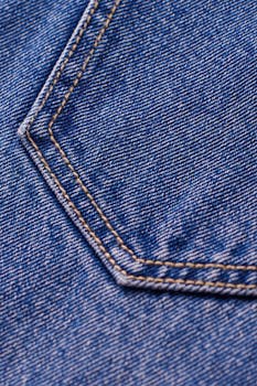 Detailed macro shot of blue denim with visible stitching and pocket design.