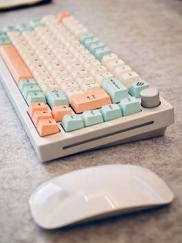 Pastel-colored mechanical keyboard and white mouse on a soft surface, perfect for tech-themed content.