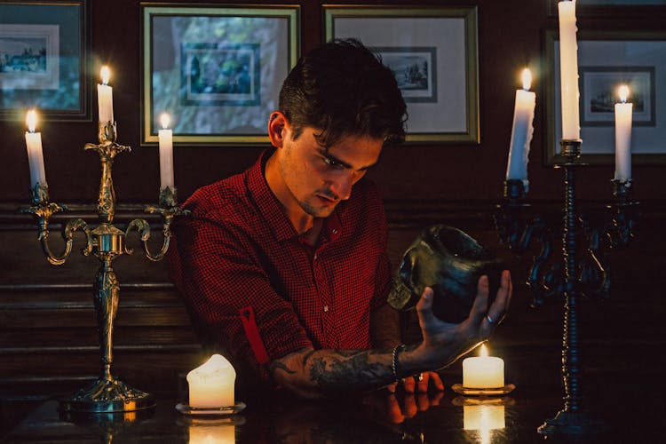 Man Holding And Looking At A Skull 