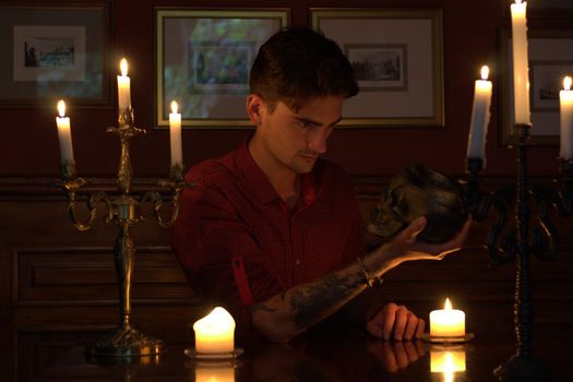 Man Holding and Looking at a Human Skull 