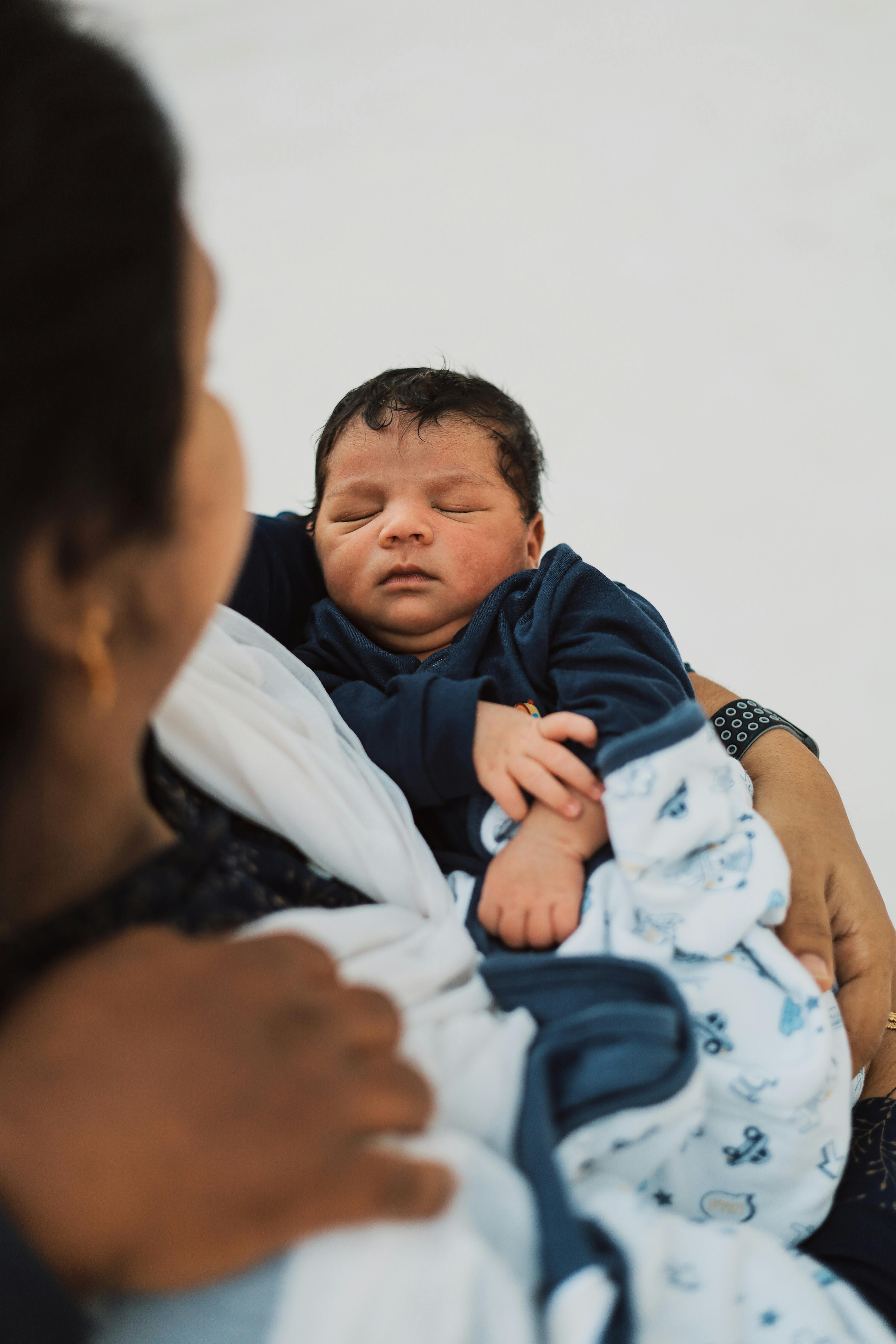 cute baby boy sleeping on his mother s arm