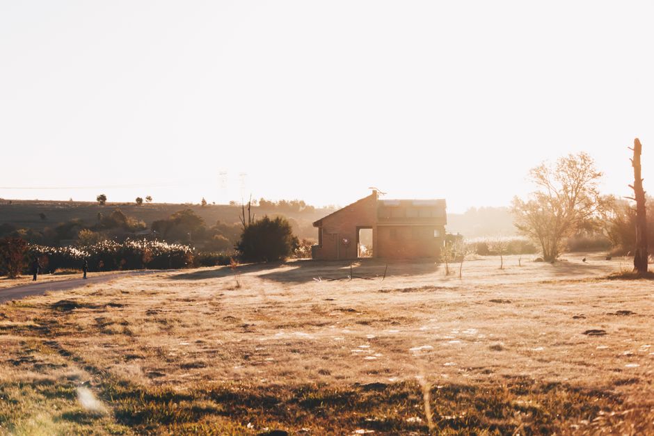 A charming farmhouse in Pretoria bathed in golden sunlight during a serene sunset.