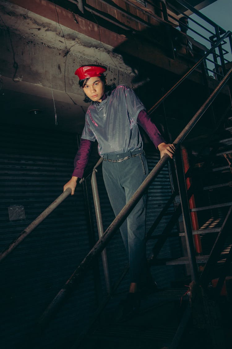 Man In Red Hat Standing On Top Of Stairs