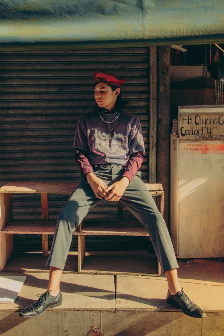 Man Sitting On Discarded Piece Of Furniture