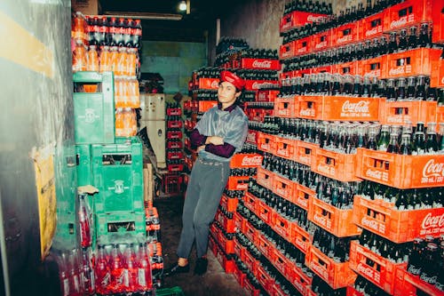 A Fashionable Man Leaning on Coca Cola Drinks