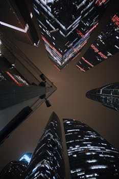 Dramatic low-angle view of Moscow's skyscrapers at night, capturing urban architecture.