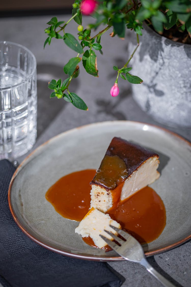 A Slice Of Delicious Cream Cheese Cake With Caramel Sauce On Gray Plate