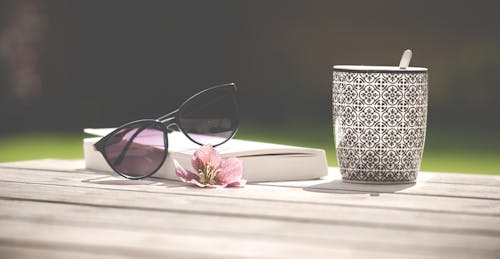 Free Photo of Black Sunglasses Beside Ceramic Mug Stock Photo