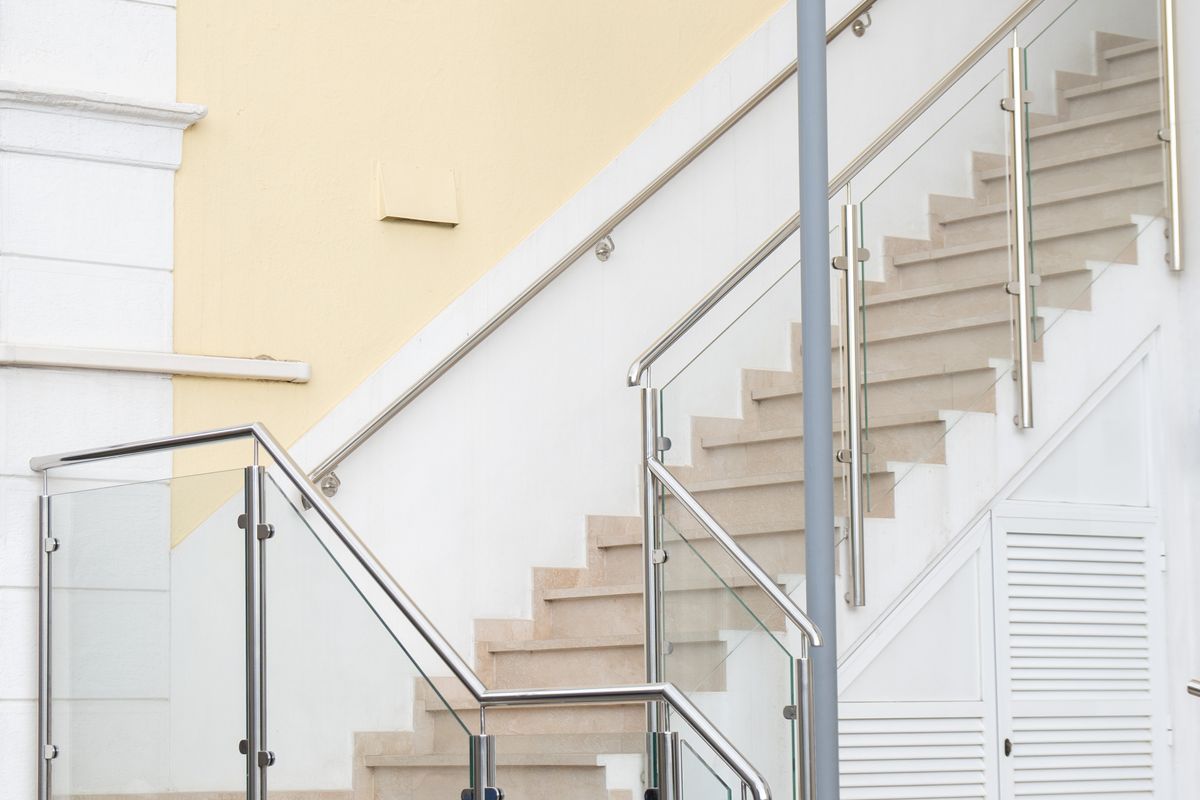 Scară interioară elegantă cu balustradă din sticlă, într-o clădire modernă