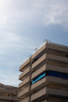 A modern apartment building under a clear blue sky with a minimalist design.