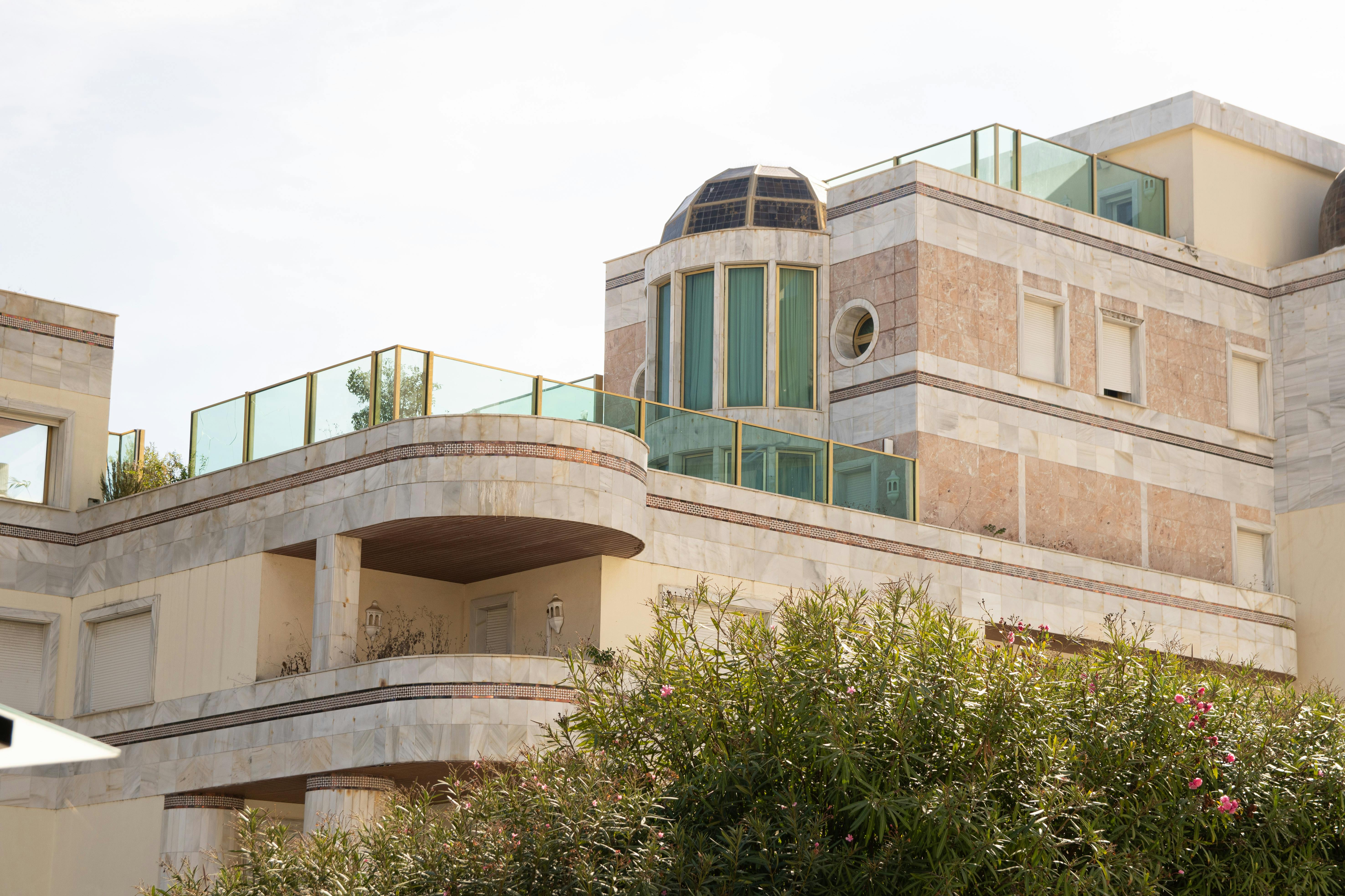 Contemporary architecture with glass balconies and decorative stone facade.