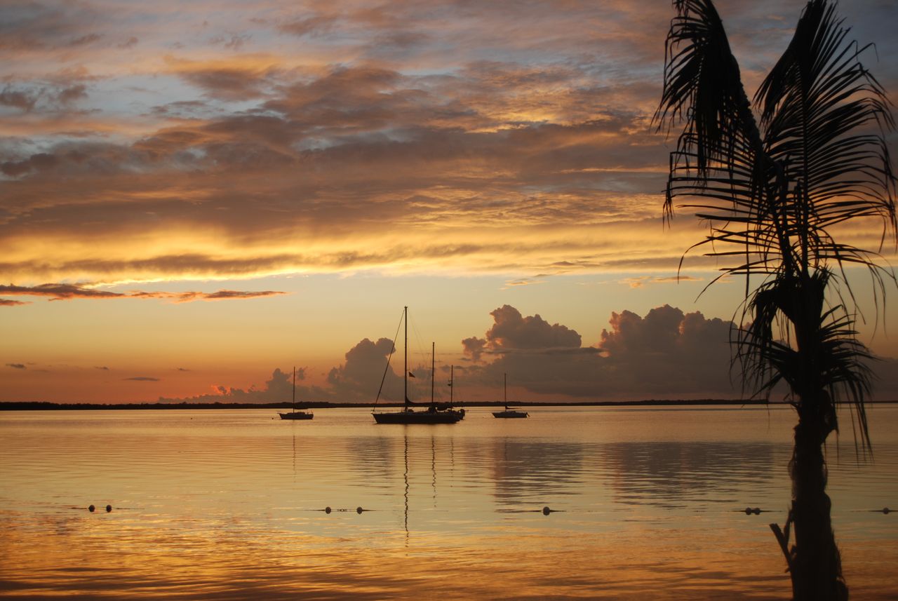 peaceful sunset view with sailboats and a tranquil ocean reflecting vi