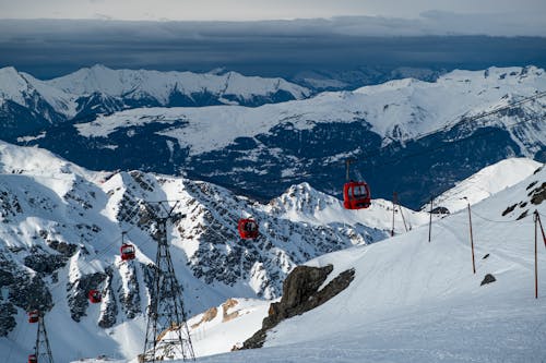 Red Cable Cars over Snow Covered Mountain