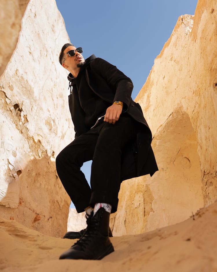 Man In Black Clothes Between Rocks In The Sun