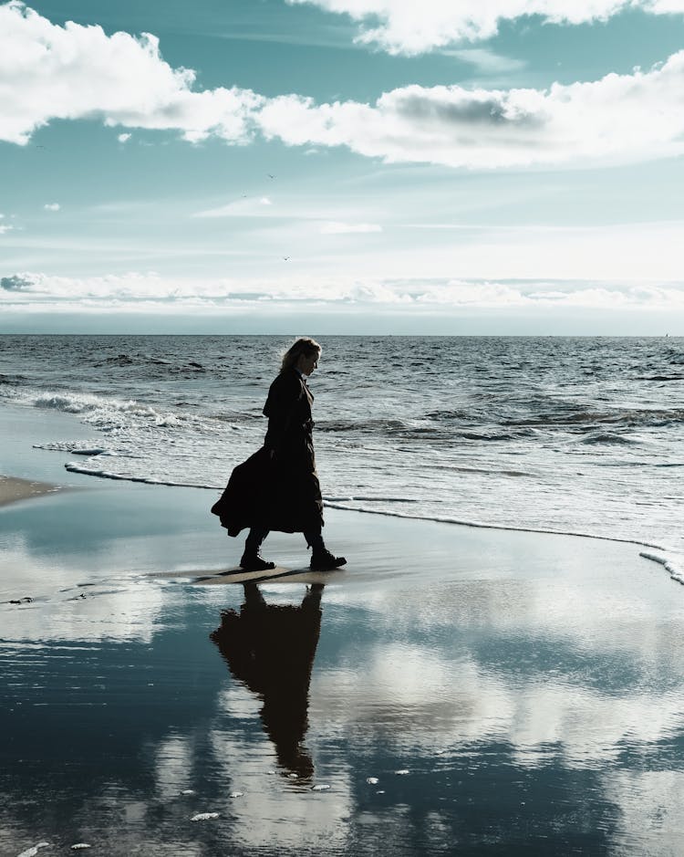 Side View Of A Woman Walking On The Beach