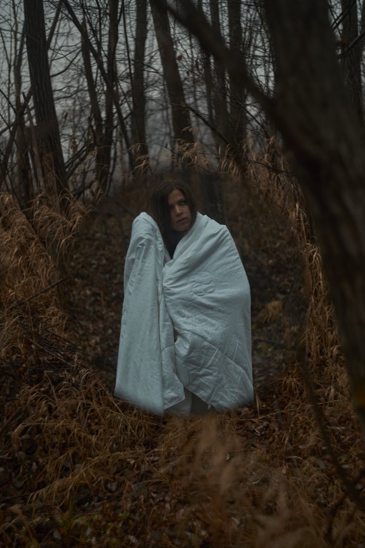 A Woman With A Blanket In A Forest