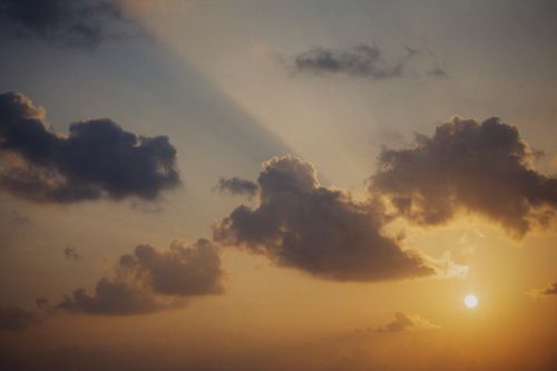 Free A stunning sunset with dramatic clouds and sunrays creating a warm, scenic view. Stock Photo