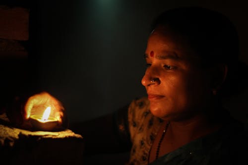 Woman in the Dark Staring at the Lighted Candle 