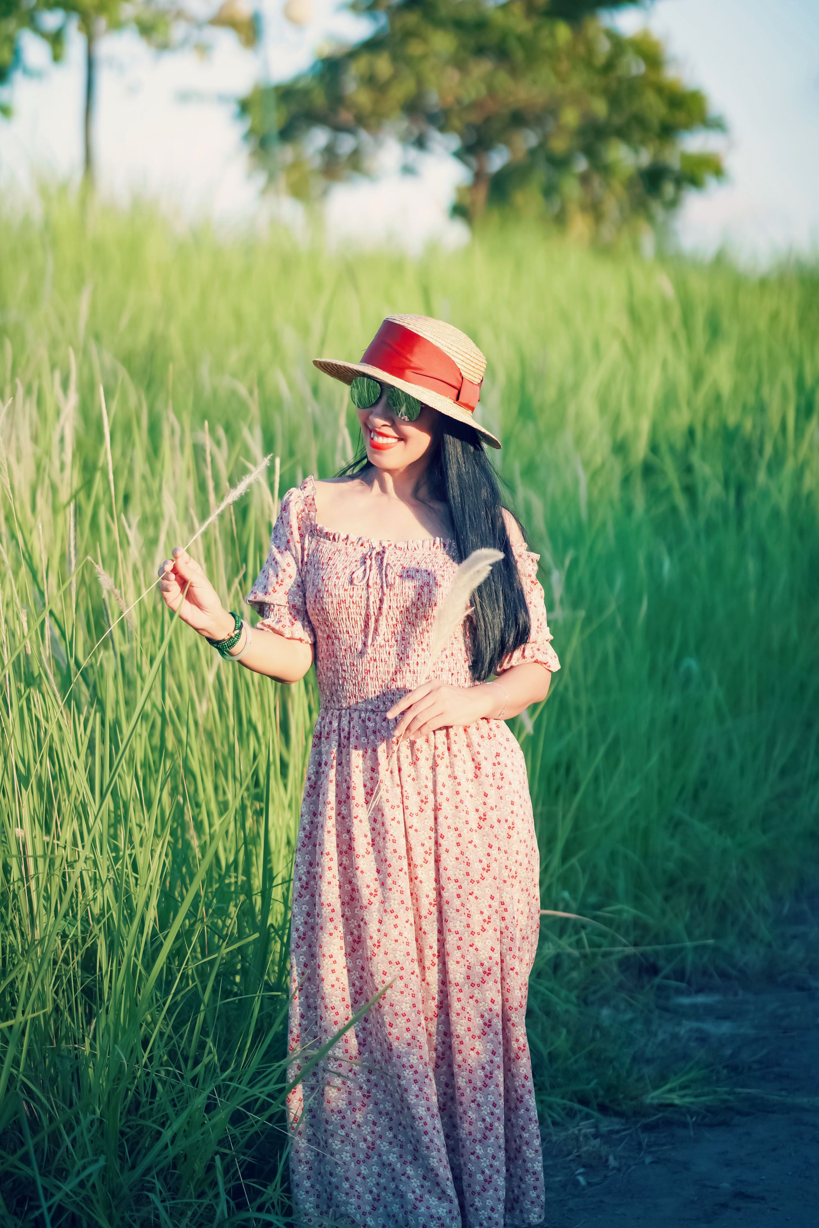 Woman in a Long Dress Standing in a Grassy Field · Free Stock Photo