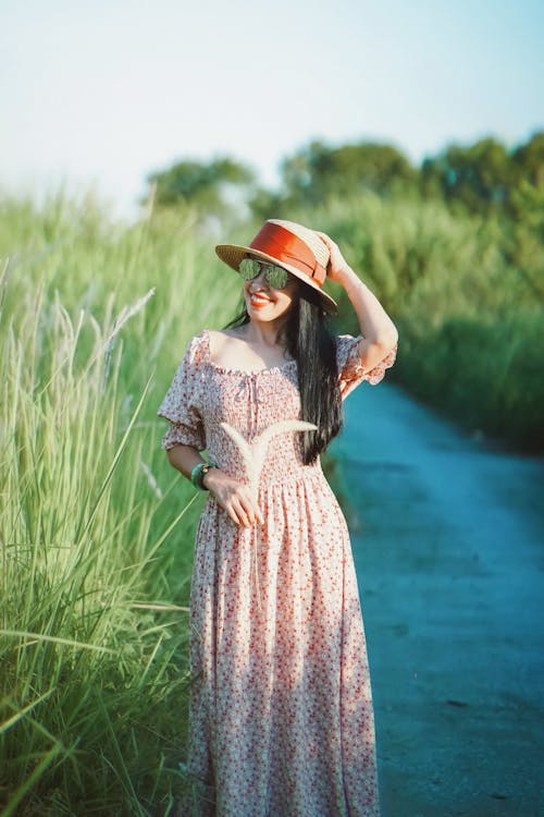 Woman in Floral Dress Standing beside Grass
