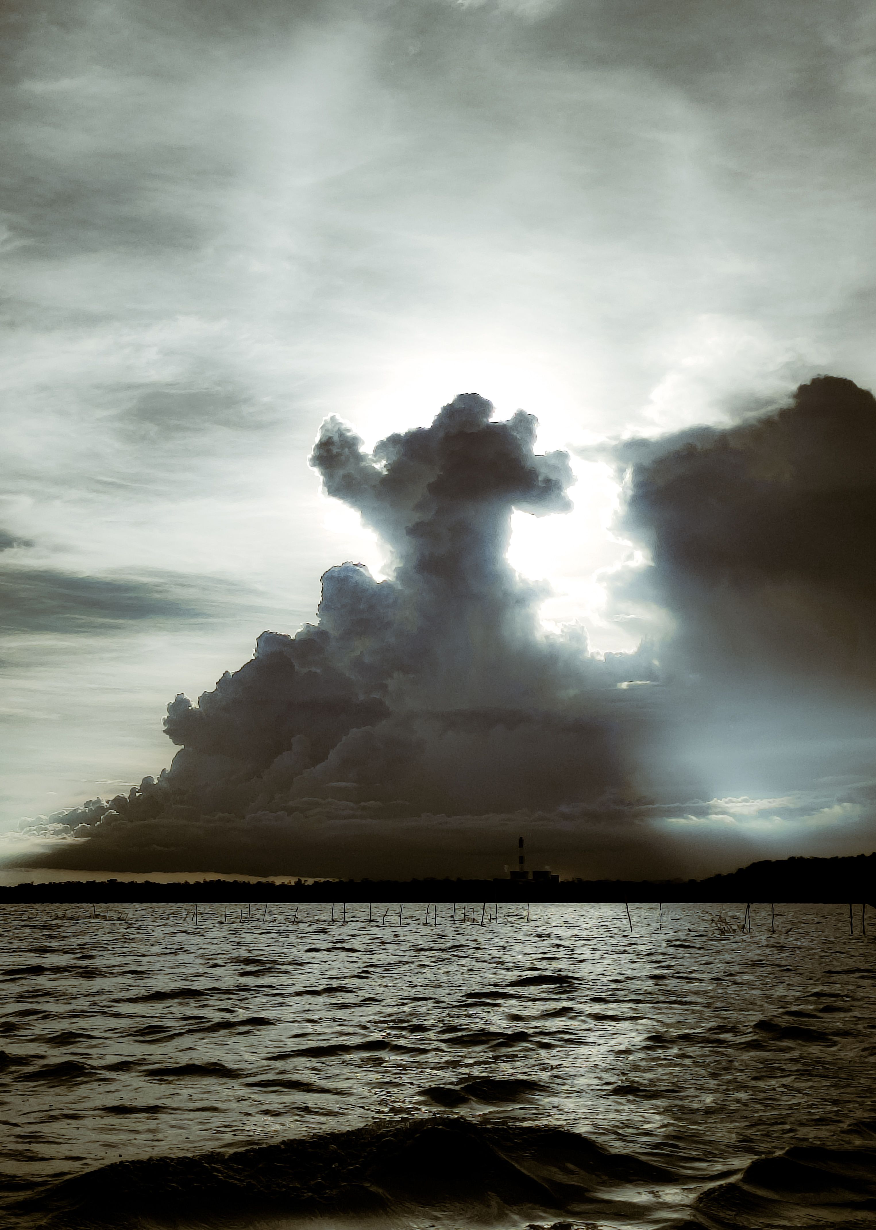 A stunning cloud formation over a serene lake captures the essence of a dramatic sunset.